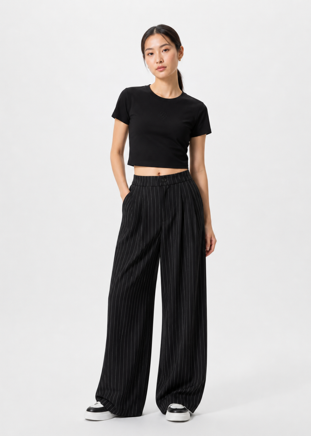petite women 1m58 wearing a black crop top and wide-leg pants on a white background