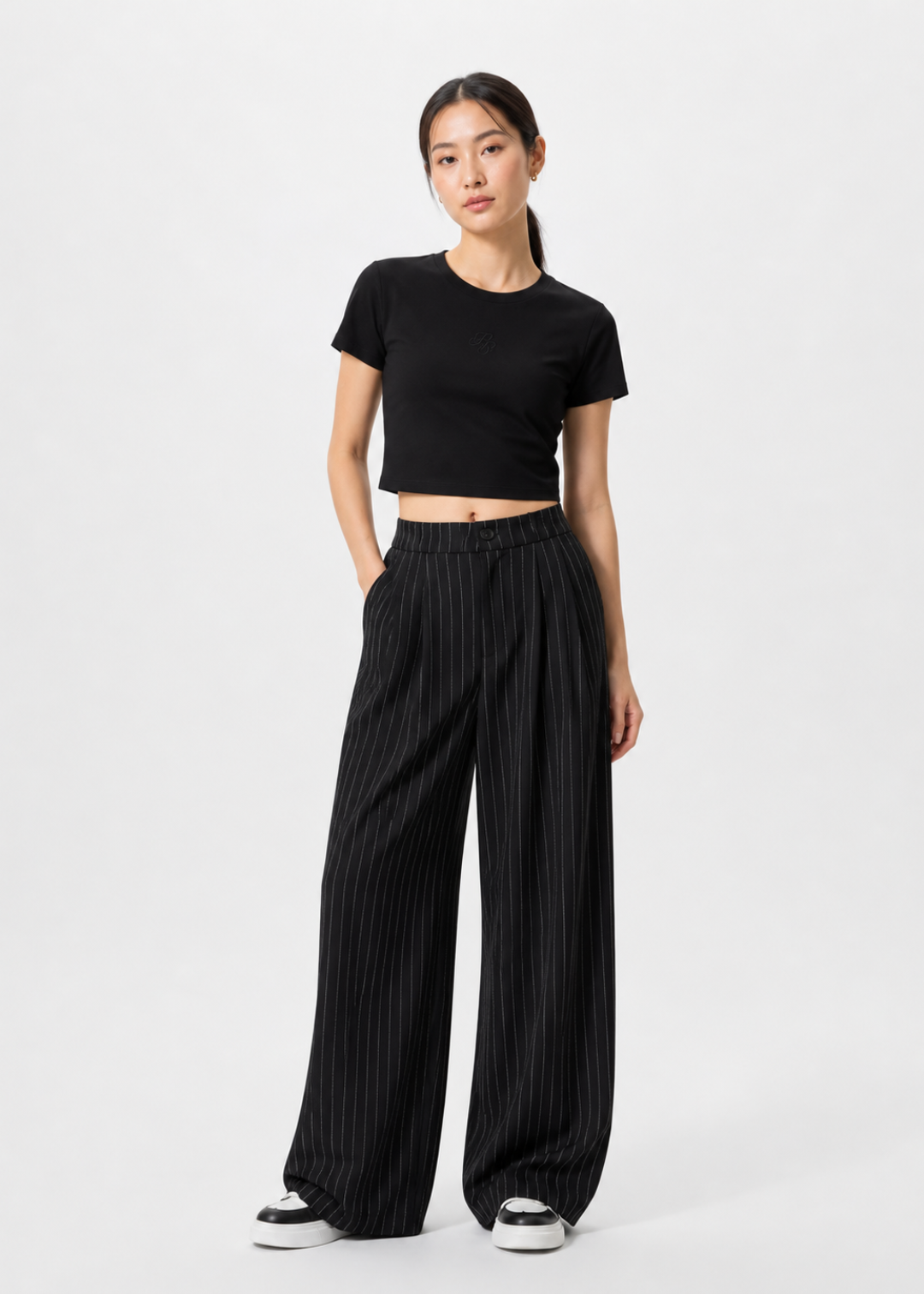 petite women 1m58 wearing a black crop top and wide-leg pants on a white background