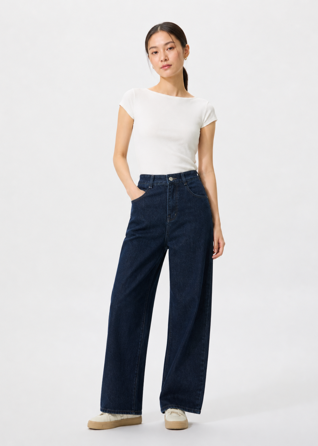 petite woman 1m58 wearing a white t-shirt and dark blue jeans on a white background