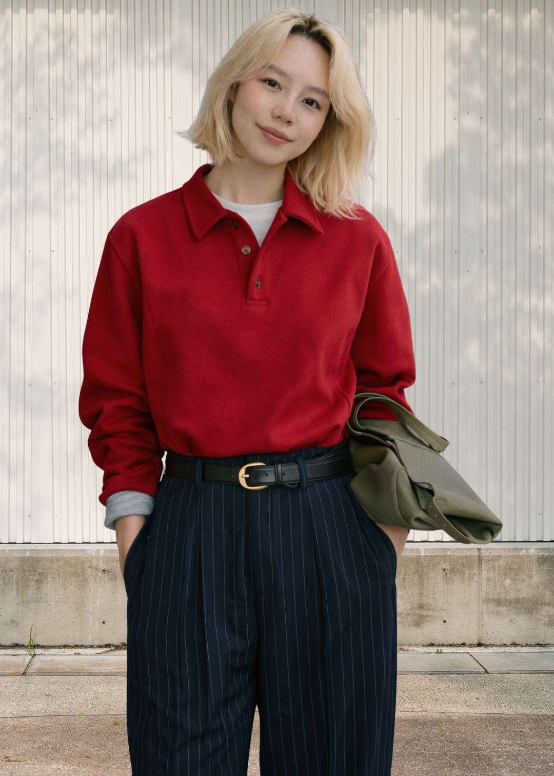 150cm height women wearing a red polo shirt and dark pinstripe pants standing against a light-colored wall.