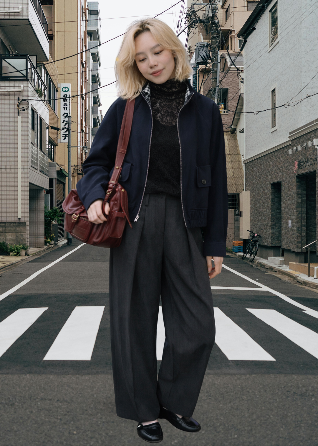petite women around 155cm height standing on a city street wearing a dark outfit with a red bag.